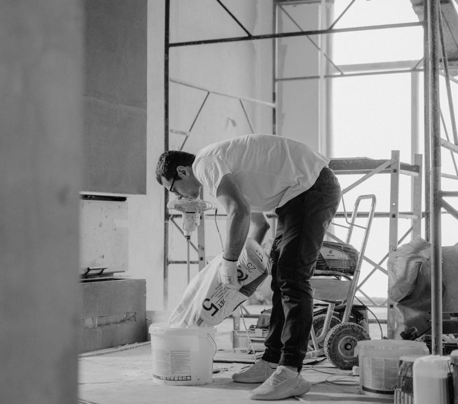 Man in White T-shirt and Black Pants Holding Plastic Bag