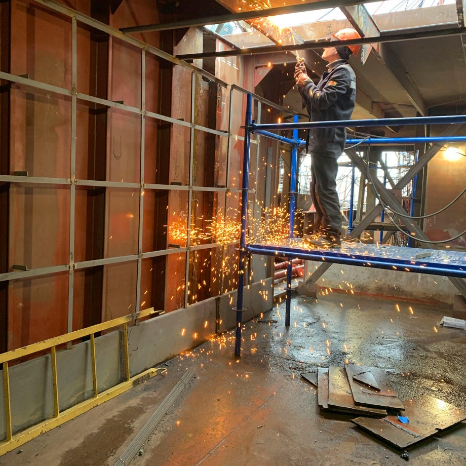 Welder working inside industrial building